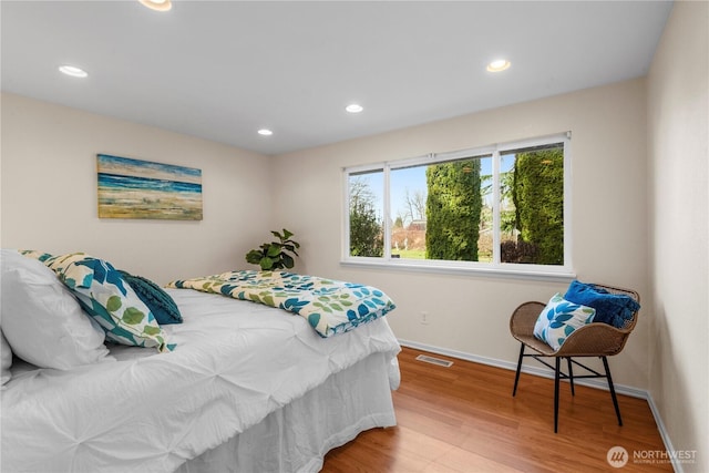 bedroom with baseboards, visible vents, wood finished floors, and recessed lighting