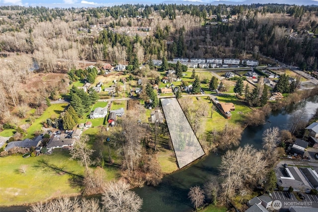 birds eye view of property with a water view and a forest view