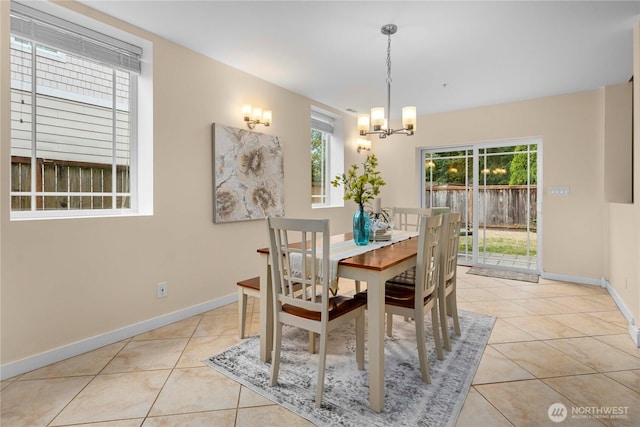 dining room with light tile patterned floors, a wealth of natural light, and a notable chandelier