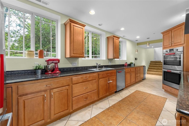 kitchen with recessed lighting, appliances with stainless steel finishes, a healthy amount of sunlight, light tile patterned flooring, and a sink