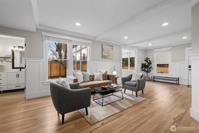 living room with light wood-type flooring, ornamental molding, beamed ceiling, and recessed lighting