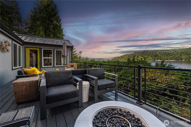 deck at dusk featuring outdoor lounge area and a forest view