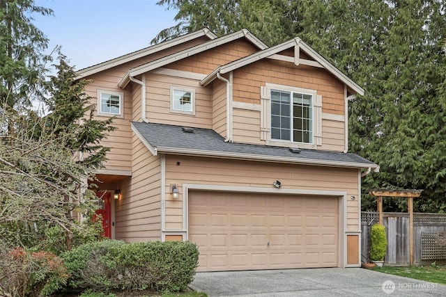 craftsman house with a garage, roof with shingles, driveway, and fence