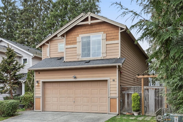 view of front facade with fence, a garage, driveway, and a shingled roof