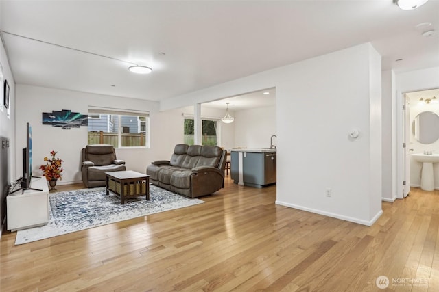 living room with baseboards and light wood finished floors