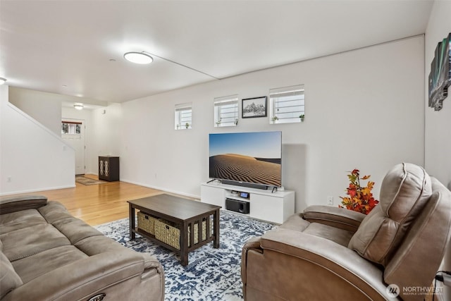 living area featuring stairs, wood finished floors, and baseboards