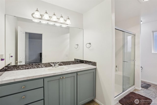 bathroom with a shower stall, vanity, and baseboards