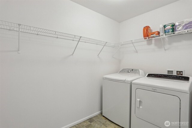 clothes washing area with laundry area, independent washer and dryer, and baseboards