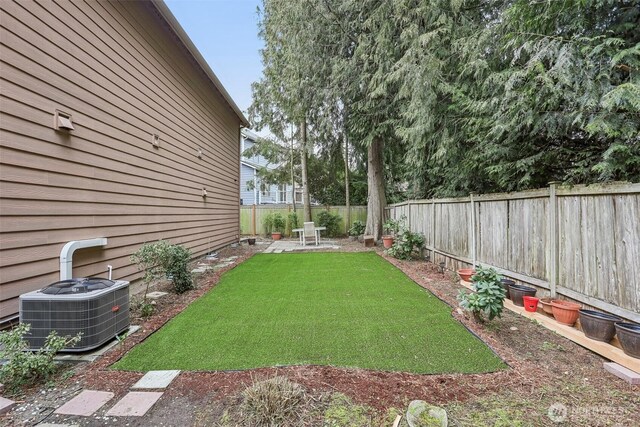 view of yard with central AC unit and a fenced backyard