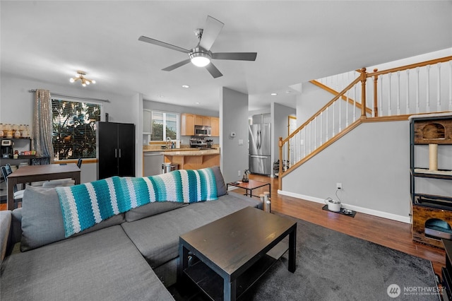 living area with baseboards, a ceiling fan, wood finished floors, stairs, and recessed lighting