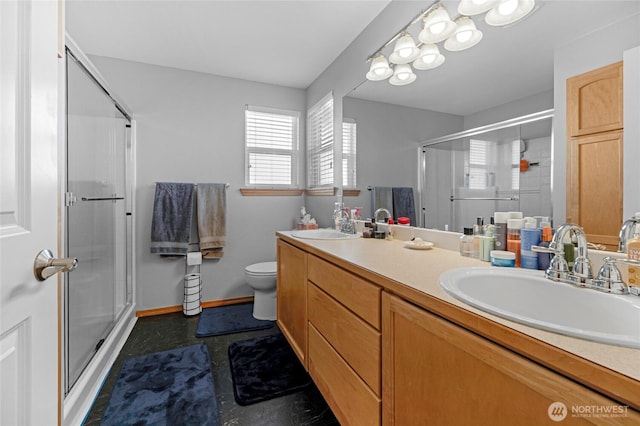 full bath with double vanity, a stall shower, a sink, and toilet