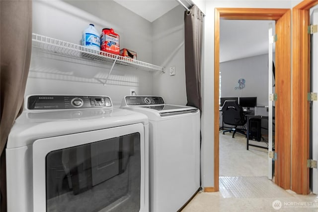 laundry room with washer and dryer and light colored carpet