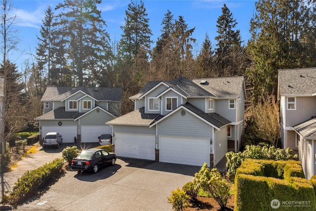 traditional-style house featuring a garage, driveway, and a shingled roof