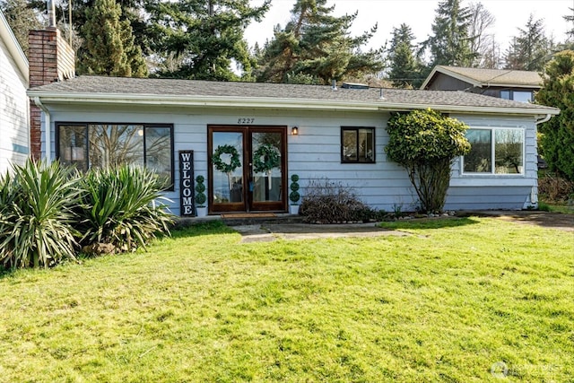 ranch-style house featuring a chimney and a front lawn