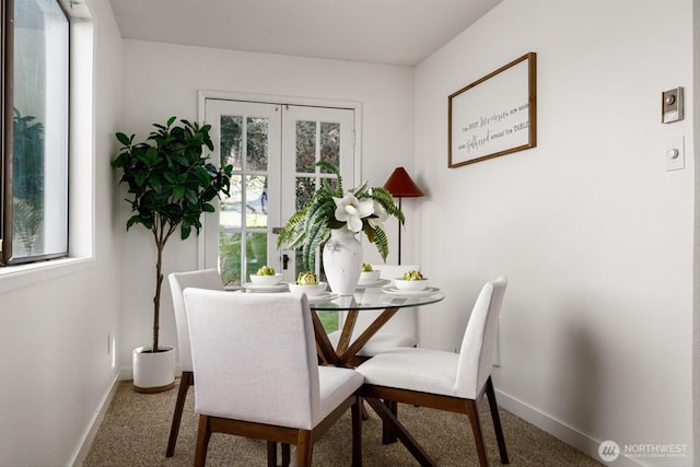 carpeted dining room featuring baseboards