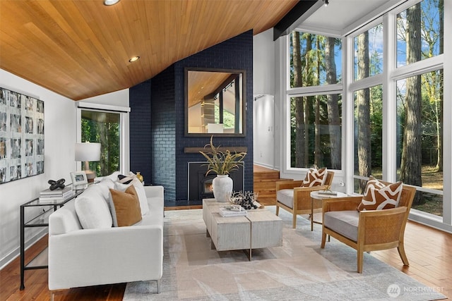 sunroom / solarium featuring wooden ceiling, a fireplace, and vaulted ceiling with beams