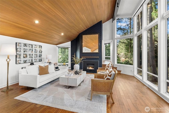 sunroom with a large fireplace, vaulted ceiling, and wooden ceiling