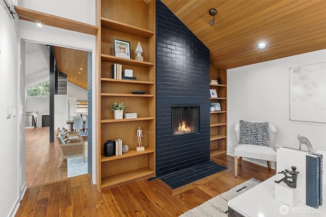 sitting room with built in features, a fireplace, lofted ceiling, wood ceiling, and hardwood / wood-style flooring