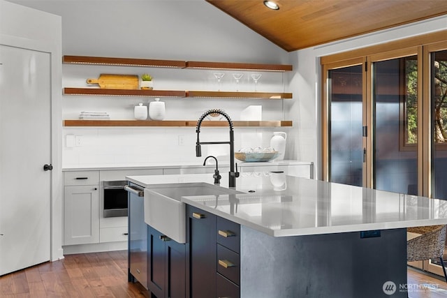 kitchen featuring lofted ceiling, dark wood-type flooring, light countertops, decorative backsplash, and open shelves