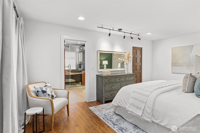 bedroom featuring ensuite bath, hardwood / wood-style flooring, and recessed lighting