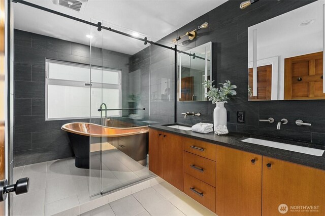 full bathroom with tile walls, visible vents, a sink, and tile patterned floors