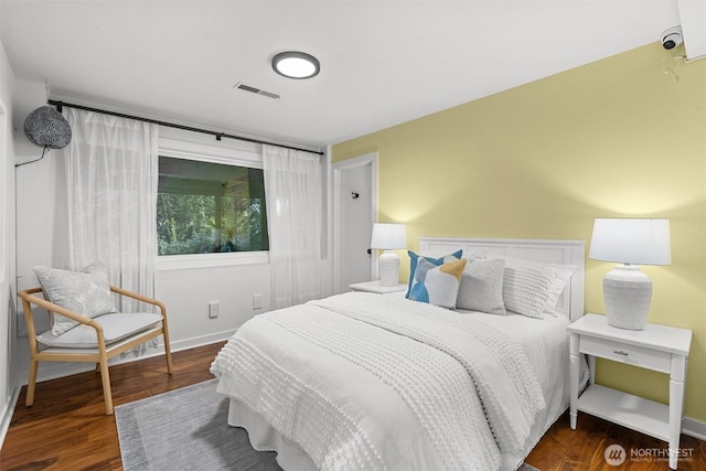 bedroom featuring wood finished floors, visible vents, and baseboards