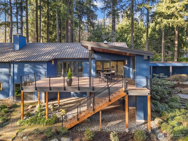 back of house featuring a standing seam roof, metal roof, stairway, and a wooden deck