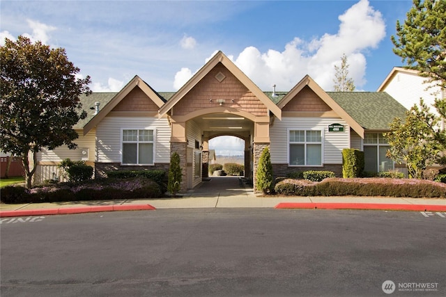 craftsman inspired home with stone siding and a shingled roof