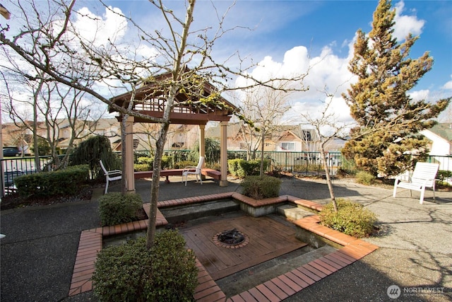 view of property's community with a fire pit, a gazebo, a patio, and fence