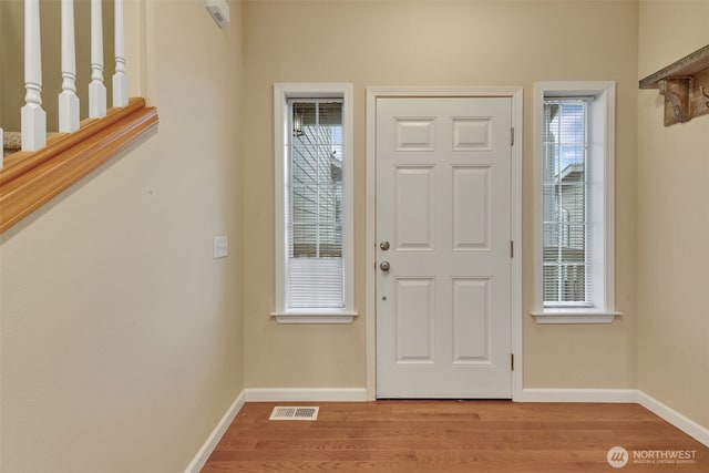 foyer featuring baseboards, visible vents, and light wood-style floors