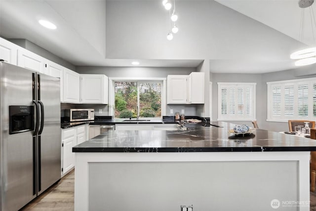 kitchen featuring light wood finished floors, appliances with stainless steel finishes, lofted ceiling, and white cabinets