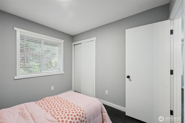 bedroom with a closet and baseboards