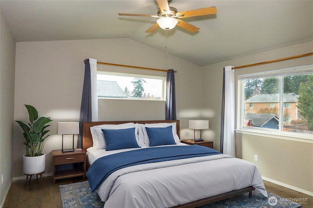 bedroom featuring baseboards, multiple windows, wood finished floors, and vaulted ceiling