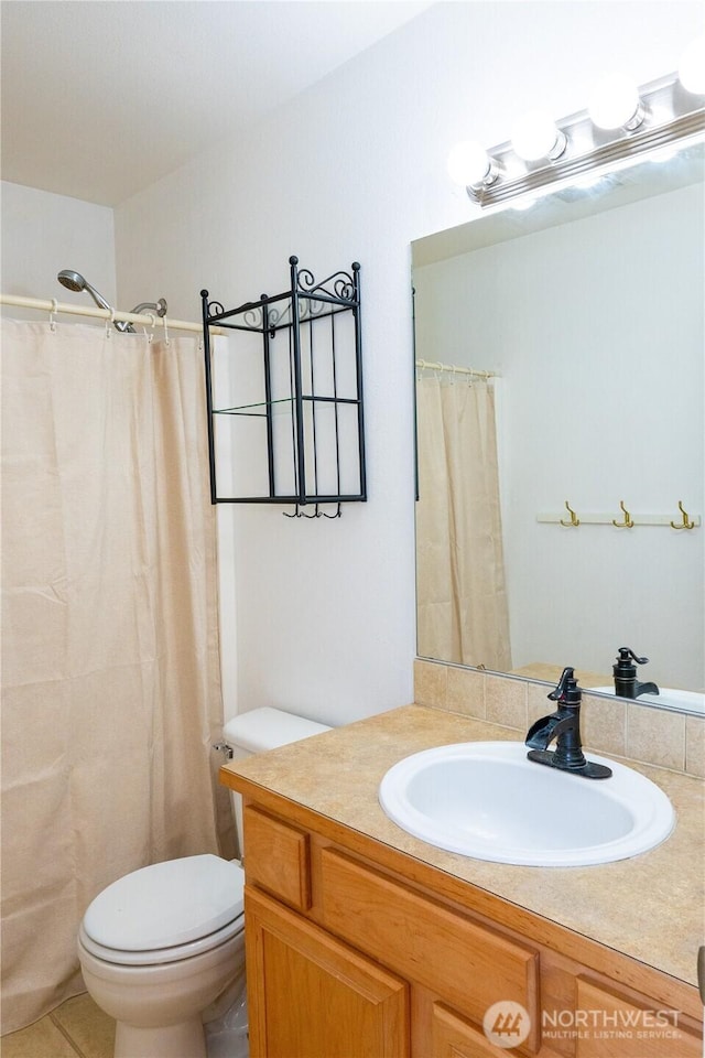 bathroom featuring tile patterned floors, toilet, and vanity