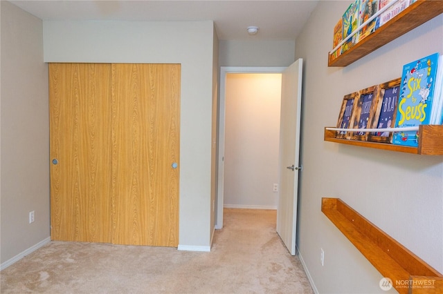 carpeted bedroom featuring baseboards and a closet