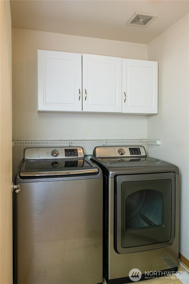 laundry room featuring independent washer and dryer, cabinet space, and visible vents