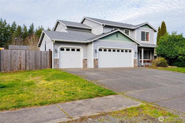 view of front of house featuring a front yard, fence, stone siding, and driveway