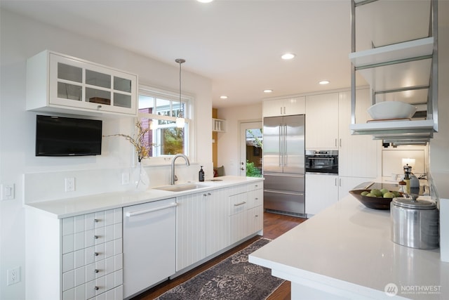 kitchen featuring recessed lighting, a sink, appliances with stainless steel finishes, pendant lighting, and white cabinetry