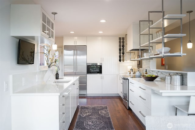 kitchen with dark wood-style floors, open shelves, a sink, stainless steel appliances, and tasteful backsplash