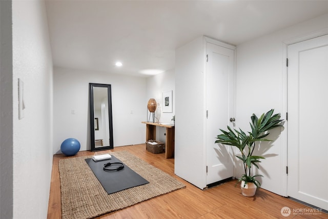 workout area featuring light wood-style floors