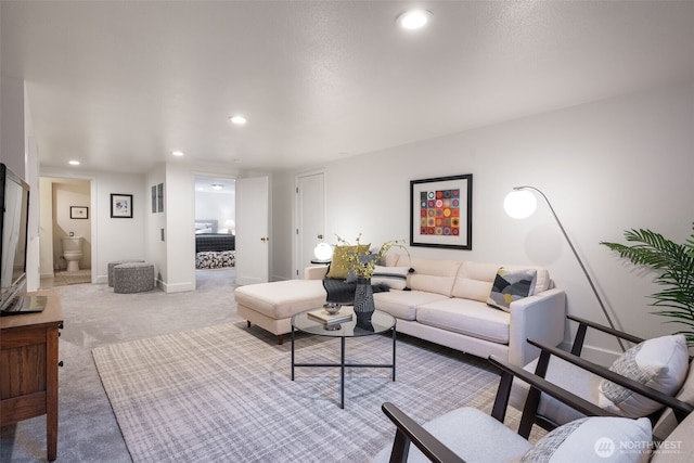 living area featuring light carpet, recessed lighting, and baseboards