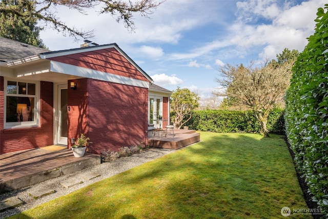 view of yard featuring french doors, a wooden deck, and fence