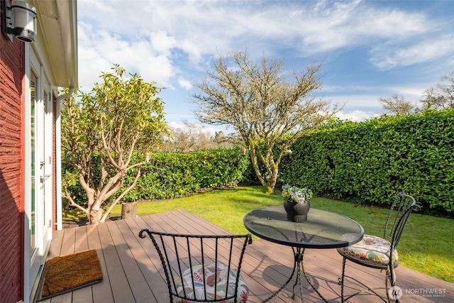 wooden terrace featuring a yard and fence