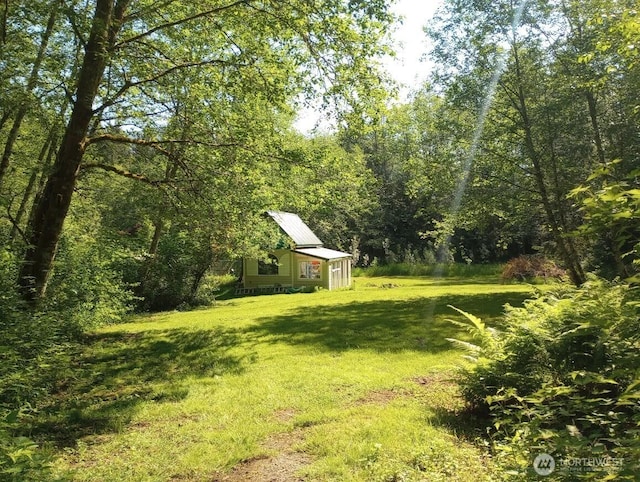 view of yard with an outbuilding and a forest view