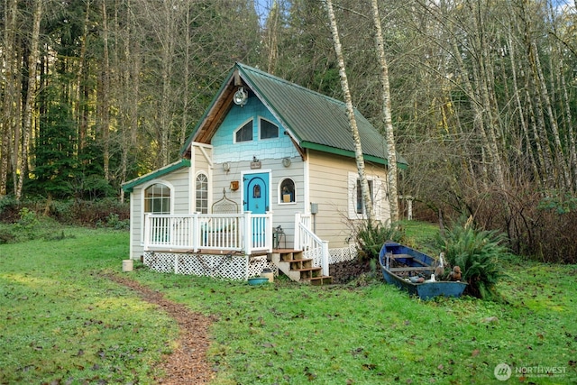 view of front facade with metal roof and a front lawn