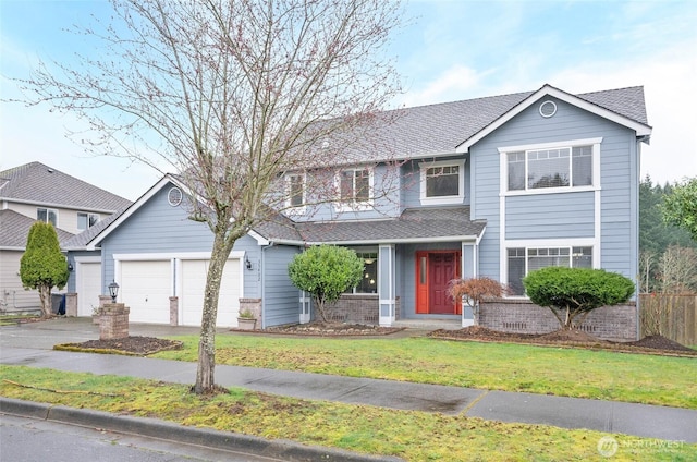 traditional-style home featuring driveway, a shingled roof, a garage, and a front lawn