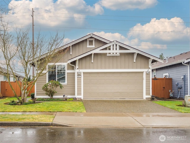 view of front of house featuring a garage, fence, aphalt driveway, and a front yard