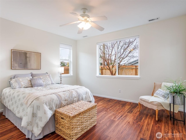 bedroom with baseboards, visible vents, ceiling fan, and wood finished floors