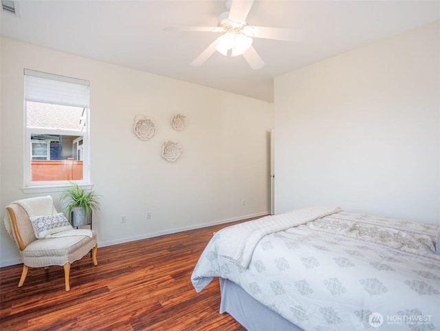 bedroom featuring ceiling fan, wood finished floors, visible vents, and baseboards