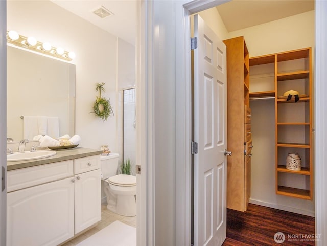 full bathroom with a closet, visible vents, vanity, and toilet